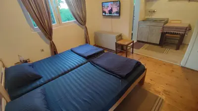a bedroom with a blue bed and a bathroom at Soba Soko in Soko Banja