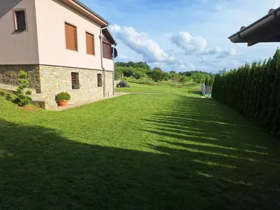 a large yard with a house and a fence at Apartmani Milosavljević in Kuršumlija