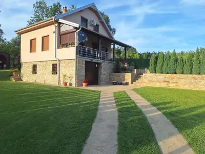 a house with a grassy yard in front of it at Apartmani Milosavljević in Kuršumlija