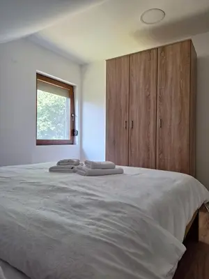 a bedroom with a large bed with wooden cabinets at Apartmani Milosavljević in Kuršumlija