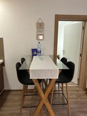 a dining room table with black chairs and a mirror at Apartman Sunce in Vrnjačka Banja