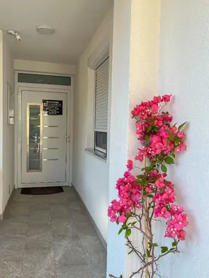a plant with pink flowers on the side of a building at Vila Sunset in Soko Banja