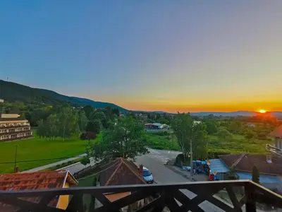 a view of a town at sunset from a balcony at Vila Sunset in Soko Banja