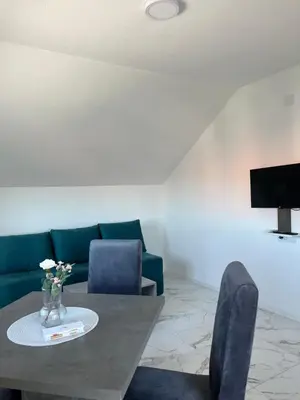 a living room with a table and a green couch at Vila Sunset in Soko Banja
