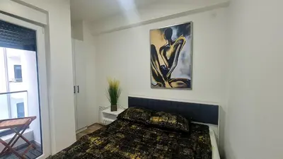 a bedroom with a bed and a painting on the wall at RELAX LUX AKVA PARK 2(K-KOMPLEX) in Jagodina