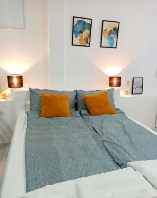 a large bed with blue sheets and orange pillows at Жути Ранац - Žuti Ranac - Yellow Backpack in Boljevac
