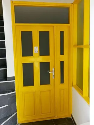 a yellow door on a building with stairs at Жути Ранац - Žuti Ranac - Yellow Backpack in Boljevac