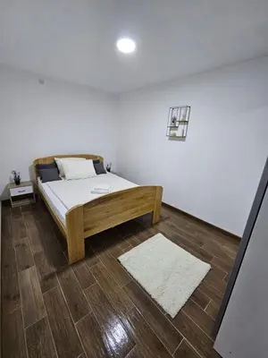 a bedroom with a bed and a wooden floor at Apartmani Bambi 2 in Soko Banja