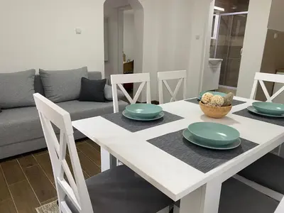 a white dining room table with green plates on it at Apartmani Bambi 2 in Soko Banja