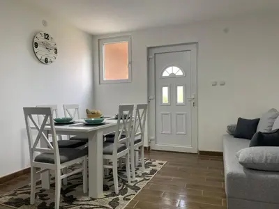 a dining room with a table and chairs and a door at Apartmani Bambi 2 in Soko Banja