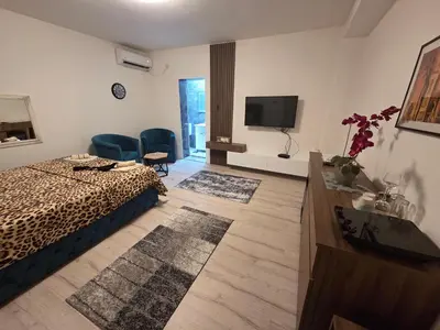 a bedroom with a bed and a television and a table at Apartmani relax in Leskovac