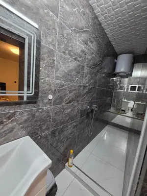 a bathroom with a shower and a sink and a mirror at Apartmani relax in Leskovac