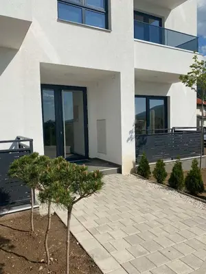 a white building with a tree in front of it at Apartman Ružica Sokobanja in Soko Banja