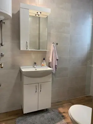 a bathroom with a sink and a mirror and a toilet at Apartman Ružica Sokobanja in Soko Banja