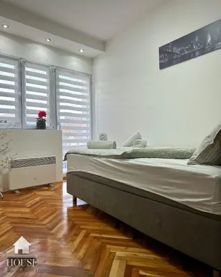 a bedroom with a large bed and a wooden floor at House Inn in Pirot