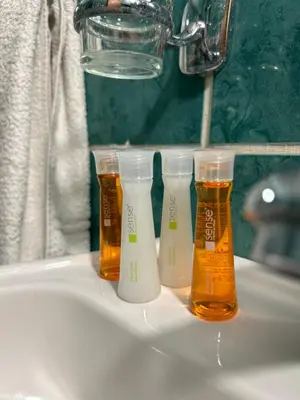 three bottles of beer sitting on a bathroom sink at House Inn in Pirot
