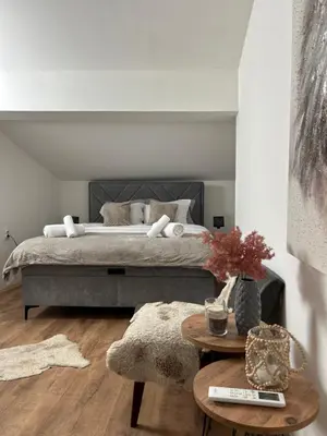a bedroom with a large bed and a table at House Inn in Pirot