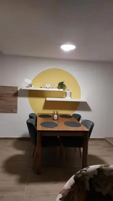 a dining room with a table and a yellow wall at MAFI AS APARTMAN in Soko Banja