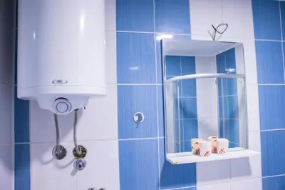 a blue tiled bathroom with a mirror and a shower at Apartmani Vrla in Vladičin Han