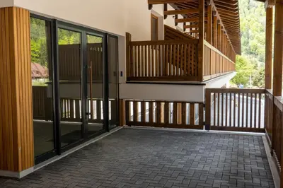 a screened porch with glass doors and a staircase at Apartman Aleni - Bela Reka, Brzeće in Brzeće