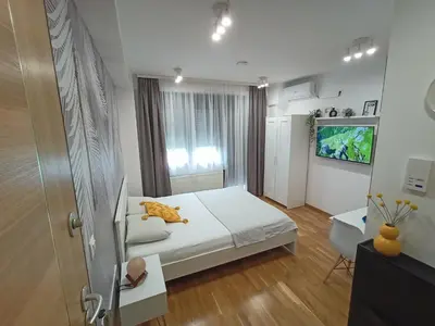 a bedroom with a bed and a tv on a wall at Apartman Luxor in Jagodina