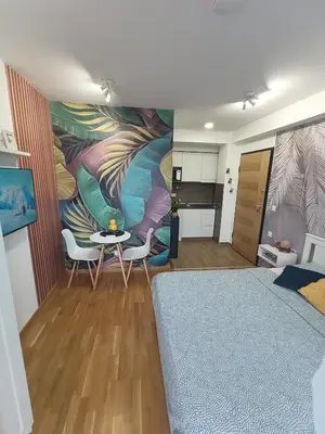a room with a bed and a table and chairs at Apartman Luxor in Jagodina