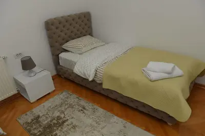 a bed with two pillows on it in a bedroom at Dobi Apartmani WING 7 in Jagodina