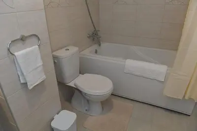 a bathroom with a white toilet and a bath tub at Dobi Apartmani WING 7 in Jagodina