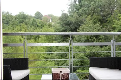 a balcony with two chairs and a view of trees at Perla Lux in Vrnjačka Banja