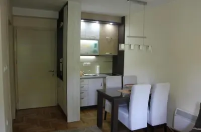 a kitchen and dining room with a table and white chairs at Perla Lux in Vrnjačka Banja