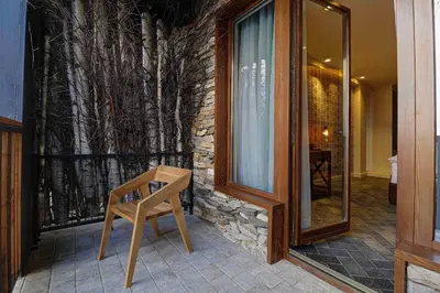 a wooden chair sitting in front of a building at Vlasinsko jezero VILA BEST in Surdulica