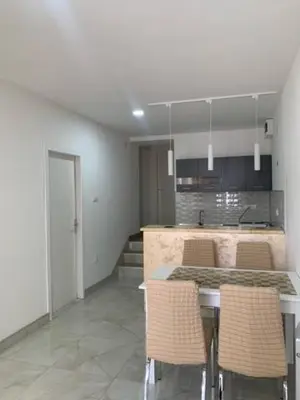 a kitchen with a table and chairs in a room at City Dream in Soko Banja