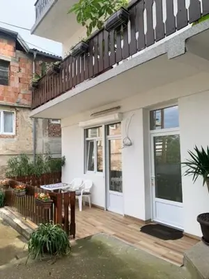 a house with a patio with a table and a balcony at City Dream in Soko Banja