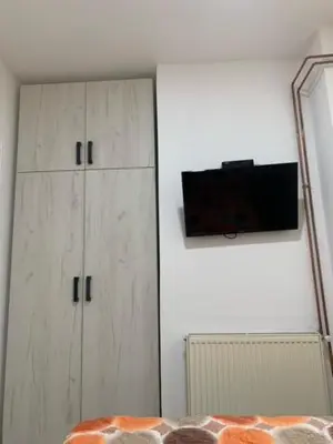 a bedroom with white cabinets and a television on the wall at City Dream in Soko Banja