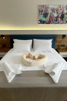 a bed with two towels and a bowl on it at ĆAKA Luxury Rooms & Restaurant in Ćuprija