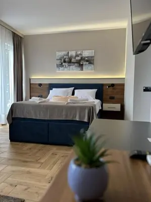 a bedroom with a bed and a table with a potted plant at ĆAKA Luxury Rooms & Restaurant in Ćuprija