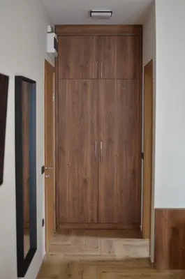 a large wooden door in a room with wooden floors at ĆAKA Luxury Rooms & Restaurant in Ćuprija