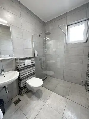 a bathroom with a shower and a toilet and a sink at ĆAKA Luxury Rooms & Restaurant in Ćuprija