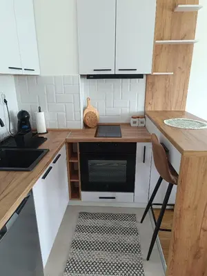 a kitchen with white cabinets and a black oven at Apartment Eight - Pirot in Pirot