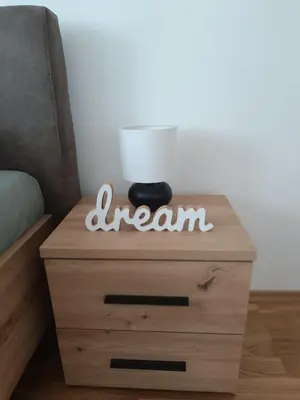 a bedside table with a lamp on top of it at Apartment Eight - Pirot in Pirot