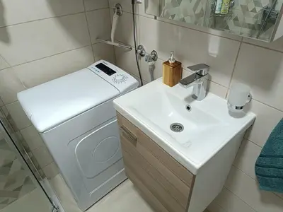 a bathroom with a sink and a washing machine at Apartment Eight - Pirot in Pirot