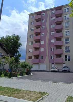 a pink building with a car parked in front of it at Apartment Eight - Pirot in Pirot
