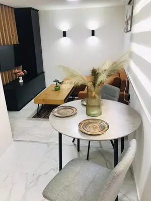 a dining room table with a vase on it at Urban Chic Studio in Niš