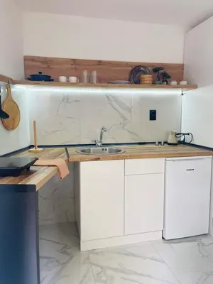 a kitchen with white cabinets and a sink at Urban Chic Studio in Niš