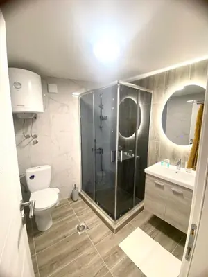 a bathroom with a shower and a toilet and a sink at Urban Chic Studio in Niš