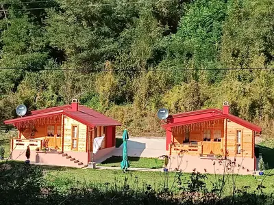 two small buildings with red roofs in a field at Milica 1 Mezdrejska 87 in Kalna