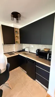 a kitchen with black cabinets and a microwave at Kovan Lux 9 Sokobanja in Soko Banja