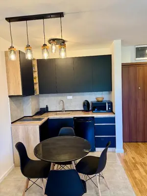 a kitchen with a table and some blue cabinets at Kovan Lux 9 Sokobanja in Soko Banja
