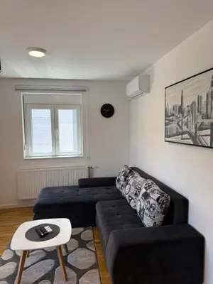 a living room with a black couch and a table at Kovan Lux 11 Sokobanja in Soko Banja