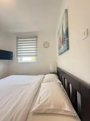 a bed in a bedroom with a clock on the wall at Kovan Lux 11 Sokobanja in Soko Banja